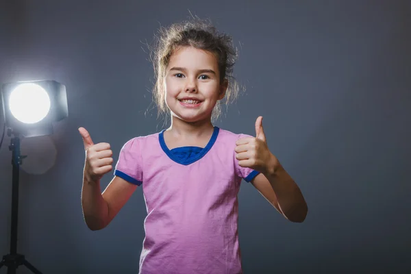 Bambina un segno mostrando pollici verso l'alto sì — Foto Stock