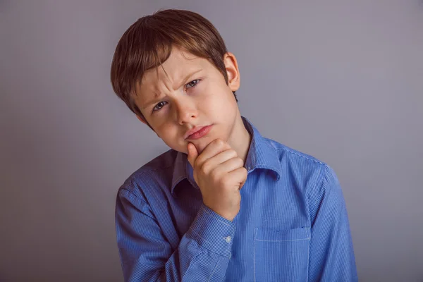 Tiener jongen dacht dat voor grijze achtergrond — Stockfoto