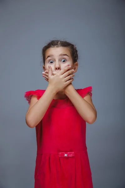 Baby girl surprised holding her hands near mouth gray — Stock Photo, Image