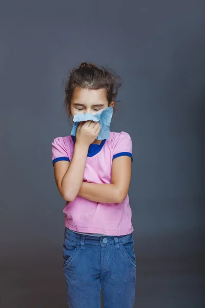 Het meisje kind is ziek in handen zakdoek op grijs — Stockfoto