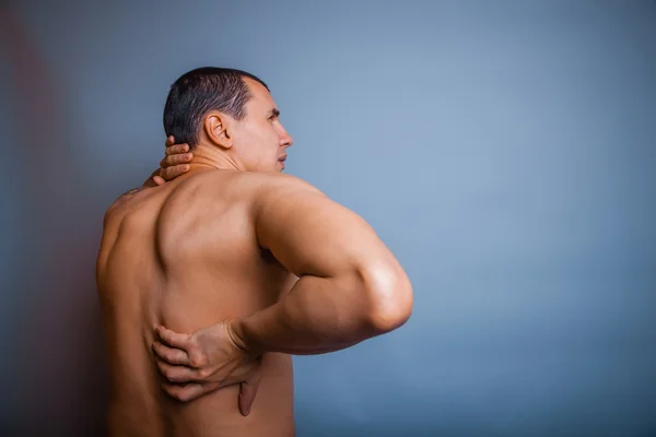 The man of European appearance brunet holding hands behind his b — Stock Photo, Image