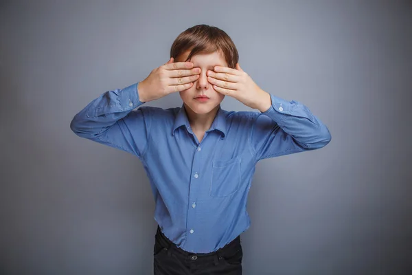 Niño en camisa ojos cerrados manos sobre fondo gris — Foto de Stock