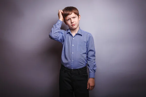 Chlapce tričko rozjímá nad šedým pozadím — Stock fotografie