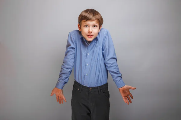 Boy shrugs from ignorance surprised — Stock Photo, Image