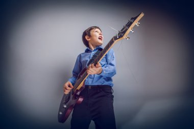 Çocuk ergenlik Avrupa görünüm söylüyor ve çapraz gitar çalar
