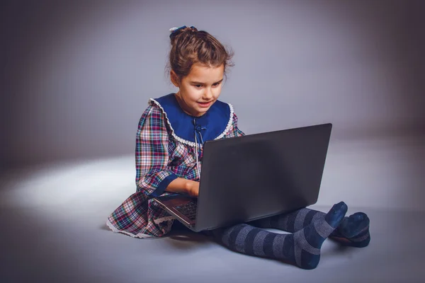 Menina adolescente 5 anos de aparência europeia parece laptop — Fotografia de Stock