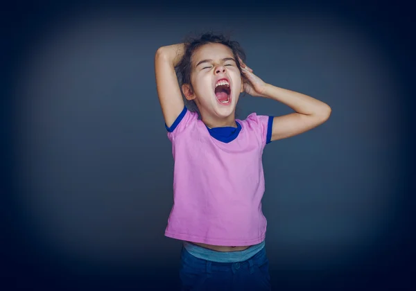 Teenie-Mädchen gähnt will auf grauem Hintergrund schlafen — Stockfoto