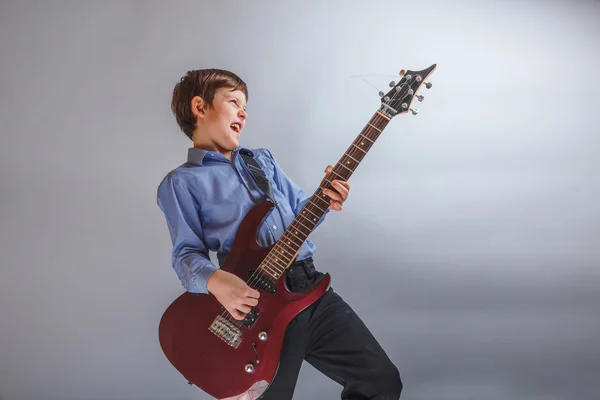 Adolescente chico marrón pelo europeo apariencia jugando guitarra, happ — Foto de Stock