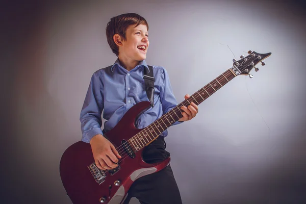 Teenager boy of 10 years European appearance smiles plays gui — Stock Photo, Image