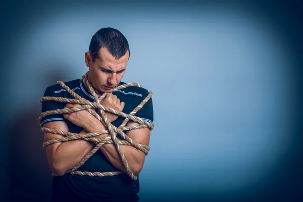 Der Mann von europäischem Aussehen brünett mit einem Seil gefesselt hängte seine — Stockfoto