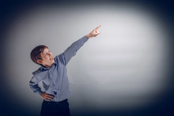 Junge Teenager von europäischem Aussehen zeigt seine Hand nach oben auf ein g — Stockfoto