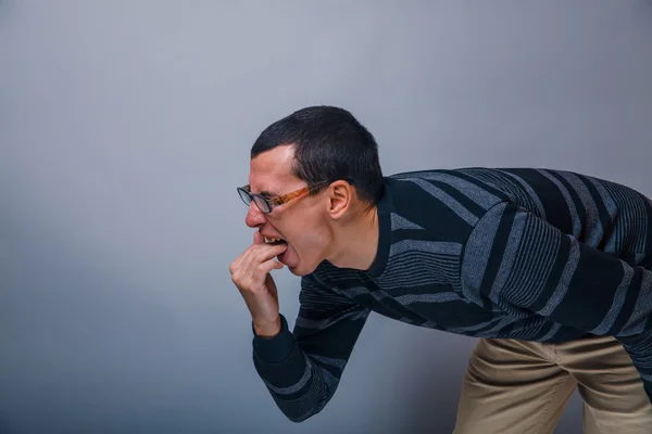 Man med europeiskt utseende år sjuka fingrar i munnen — Stockfoto