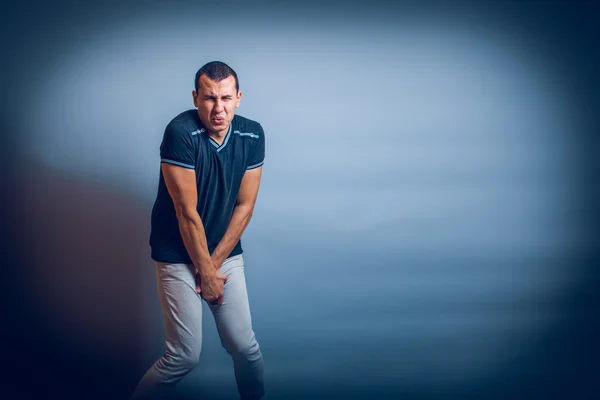 Avrupa kasık üzerinde gri bir acı içinde üzerinde ellerini tutan adam