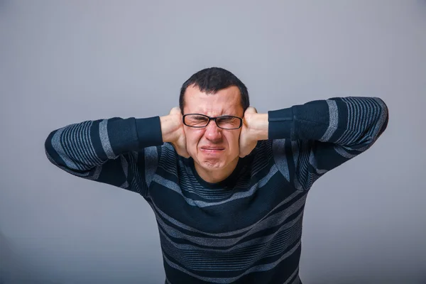 Hombre de aspecto europeo de 30 años con gafas, sus manos cubiertas —  Fotos de Stock