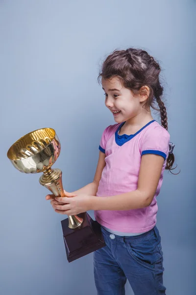 Niña de 6 años de apariencia europea sostiene una taza en su —  Fotos de Stock