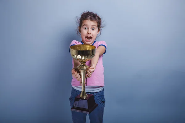 Menina criança 6 anos de aparência europeia detém uma xícara em seu han — Fotografia de Stock