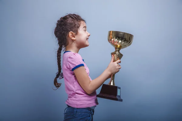 Niña de 6 años de apariencia europea sostiene una taza en su han — Foto de Stock