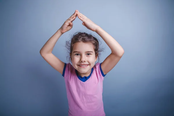 Baby girl of European appearance 6 years hands above his head on — Stock Photo, Image