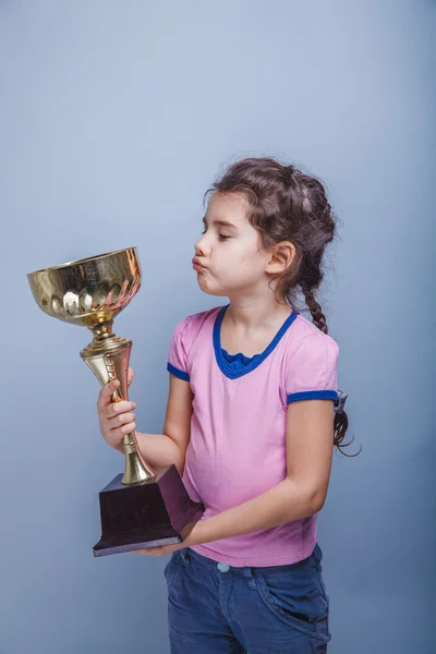 Niña de 6 años de apariencia europea sostiene una taza en su han — Foto de Stock