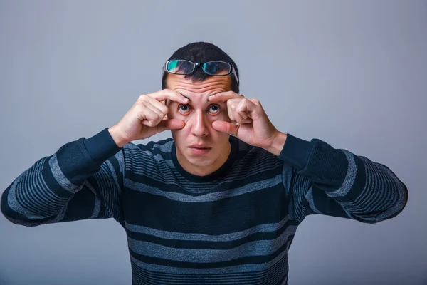 Homem de aparência europeia de cerca de trinta morenas estende os olhos com — Fotografia de Stock