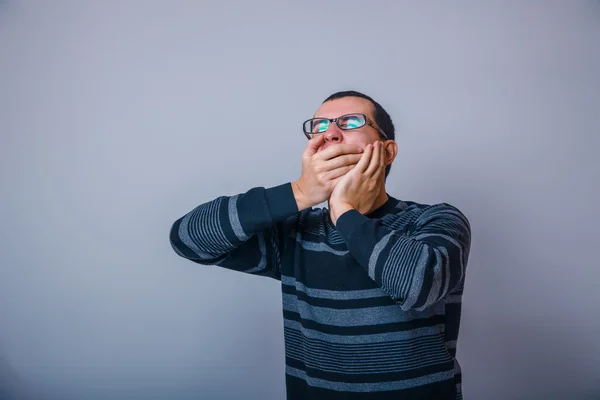Europese uitziende man van ongeveer dertig sloot zijn mond gaapt handen — Stockfoto