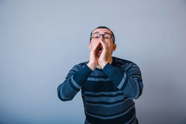 Европейский мужчина 30 лет в очках, звонит, кричит — стоковое фото
