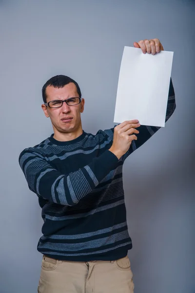 European-looking man of 30 years holding a blank sheet, resentme — Stock Photo, Image