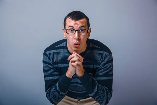 Male of European appearance brunet feels surprisingly on a gray — Stock Photo, Image