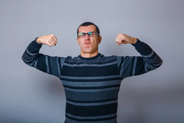 Male of European appearance brunet raised his hands and shows th — Stock Photo, Image