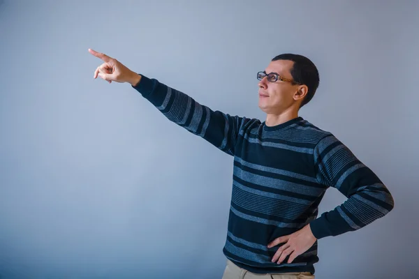 Male of European appearance brunet shows his hand up on a gray b — Stock Photo, Image