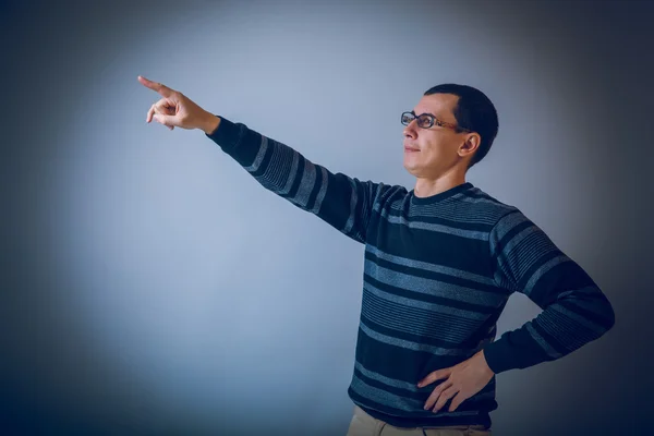 Male of European appearance brunet shows his hand up on a gray b — Stock Photo, Image