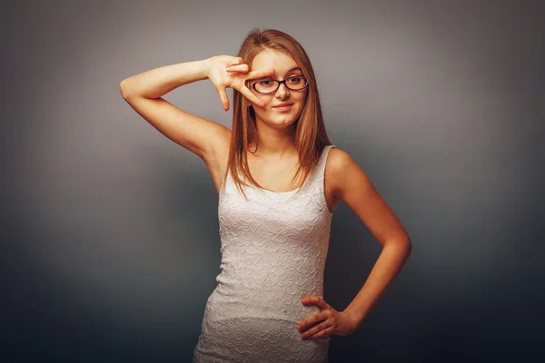 European appearance blonde girl with glasses put two fingers to — Stock Photo, Image