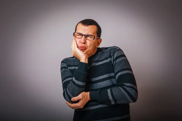 Male of European appearance brunet in a striped sweater put his — Stock Photo, Image