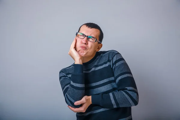 Male of European appearance brunet put his hand to his cheek on — Stock Photo, Image