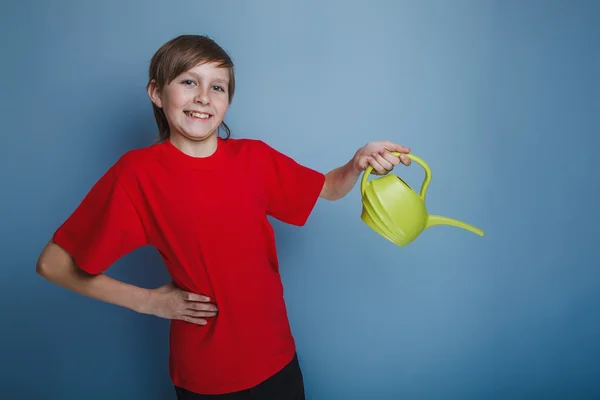 Boy teenager European appearance in a red shirt holding a yellow — Stock Photo, Image