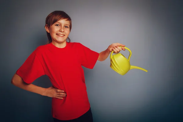 Boy teenager European appearance in a red shirt holding a yellow — Stock Photo, Image