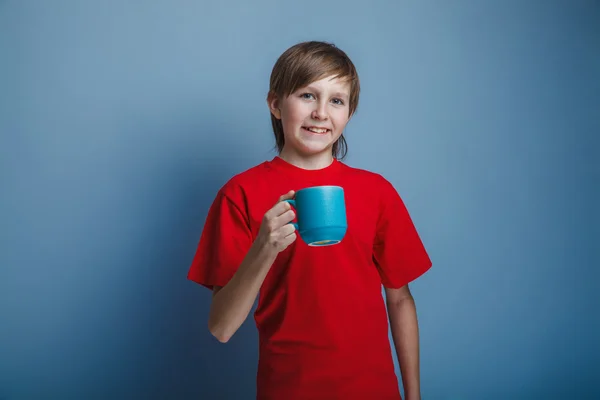 Chico de aspecto europeo de diez años sosteniendo una taza en un bac gris —  Fotos de Stock