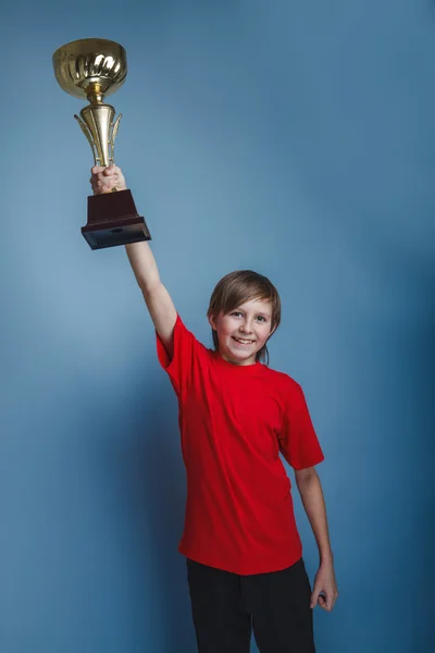 Rapaz de aparência europeia de dez anos copo, esportes, prêmio em um cinza — Fotografia de Stock