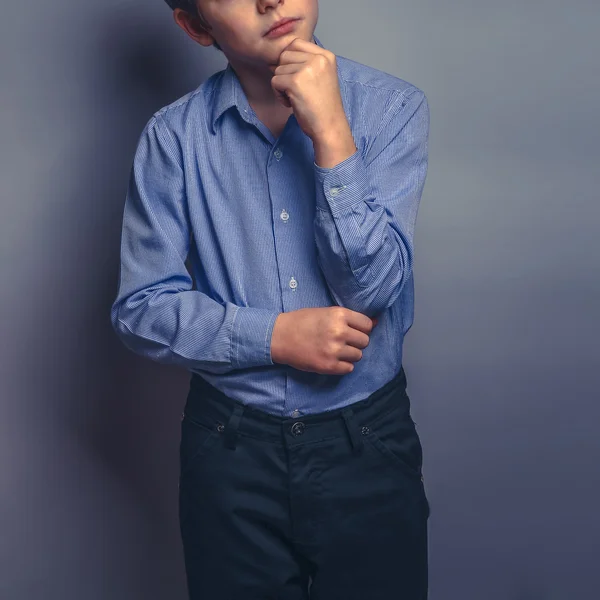 Adolescente ragazzo capelli castani di aspetto europeo tiene una mano unde — Foto Stock