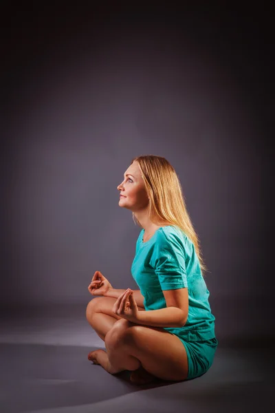 Girl blonde European appearance in a blue tracksuit in the lotus — Stock Photo, Image