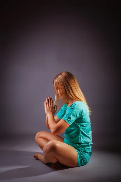 Girl blonde European appearance in a blue tracksuit meditates on — Stock Photo, Image