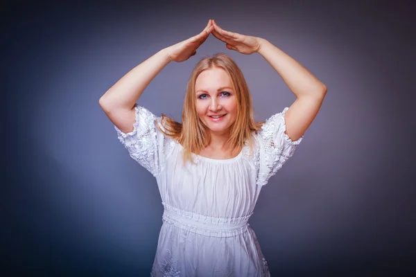 Chica rubia europea apariencia en un vestido blanco doblado sus brazos —  Fotos de Stock