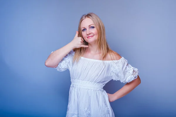 Chica rubia europea apariencia en un vestido blanco mostrando los pulgares —  Fotos de Stock