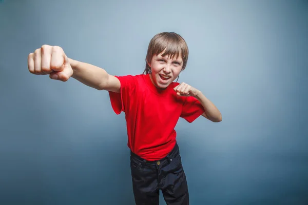 European-looking boy of ten years shows a fist, anger, danger, m — Stock Photo, Image