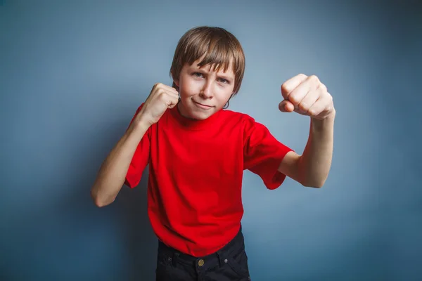 European-looking boy of ten years shows a fist, anger, threat on — Stock Photo, Image