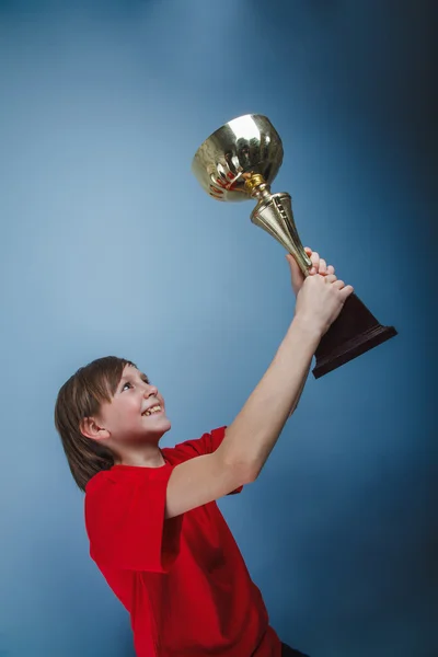 Ein Junge von zwölf europäischen Erscheinungen hält den Pokal in der Hand, die Belohnung, t — Stockfoto