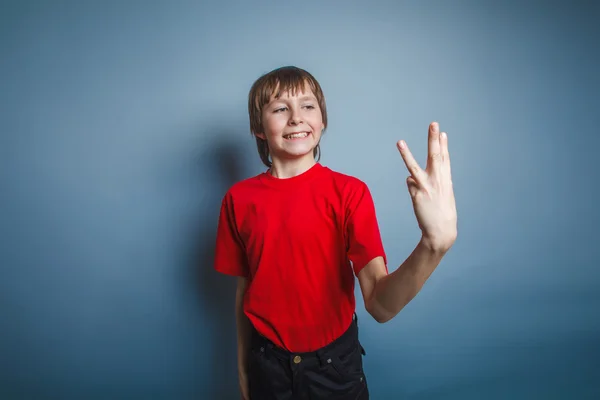 Boy teenager European appearance in a red shirt showing thumbs d — Stock Photo, Image