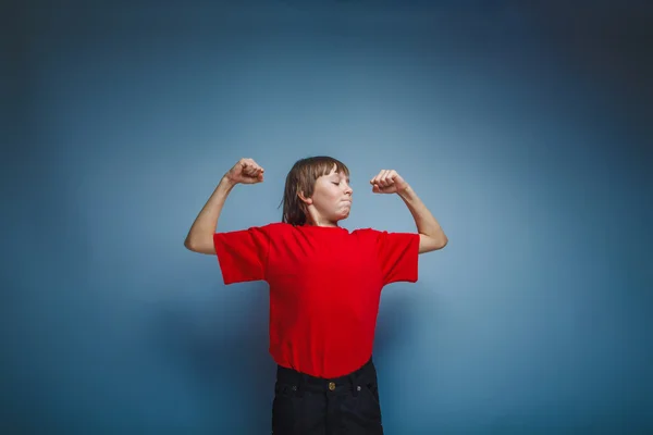 Boy teenager European appearance in a red shirt shows the power — Stock Photo, Image