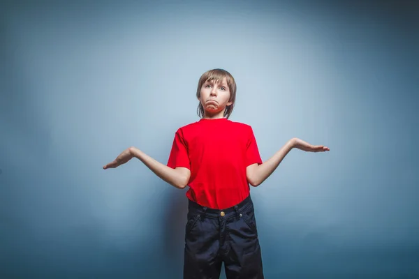 Boy teenager European appearance in a red shirt spread his arms — Stock Photo, Image
