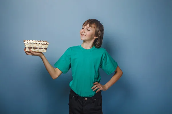 European-looking boy of ten years holding an empty basket in han — Stock Photo, Image